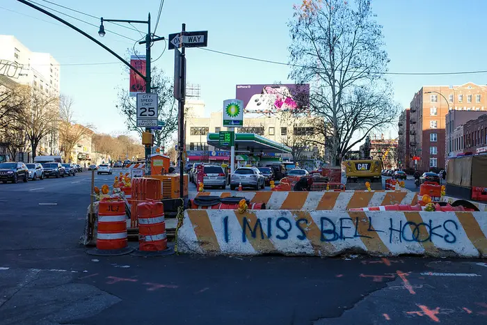 a traffic berm with "I Miss bell hooks" spray painted on it